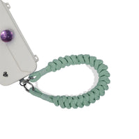 Wristlet secured to phone port during outdoor activity in mint green