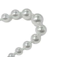 Close-up of small pearl beads on bracelet, highlighting fine details.