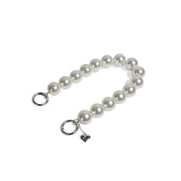 Side angle of pearl wristlet strap with silver clasps apart, showing easy grip.