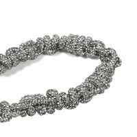 Artisanal crystal braiding detail with silver metal clasp
