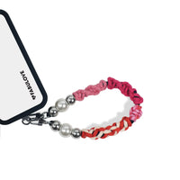 Wrist strap secured to phone case charging port via strap card