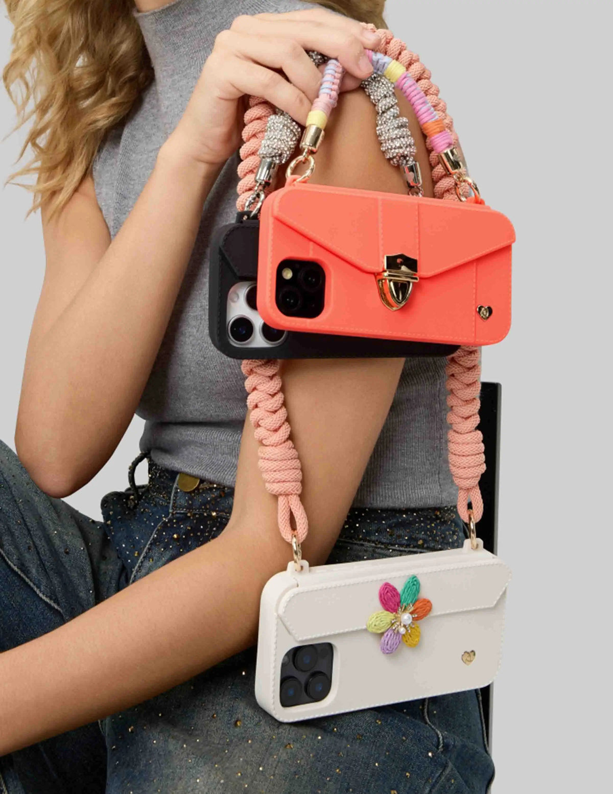 Stylish woman showcasing 3 iPhone cases with freely interchangeable straps and ornaments. MIX & MATCH to express your personal style.